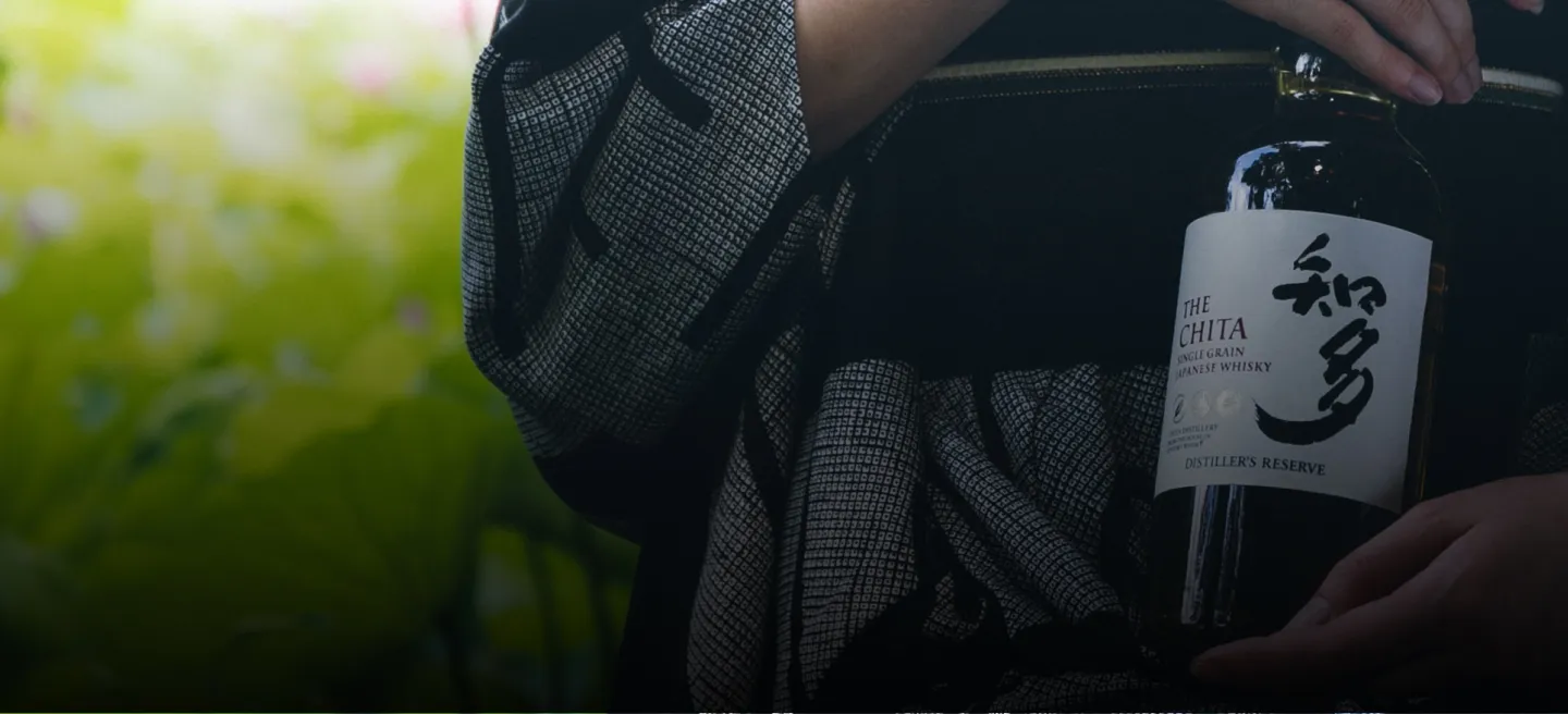 A person is holding a bottle of The Chita Whisky