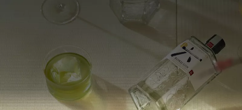 Roku gin bottle lying next to a gin glass
