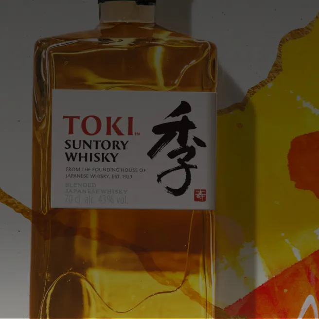 Toki Whisky bottle close up with vibrant orange and yellow art behind