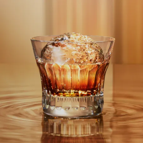 suntory whisky in old fashioned glass with large round ice in gold room