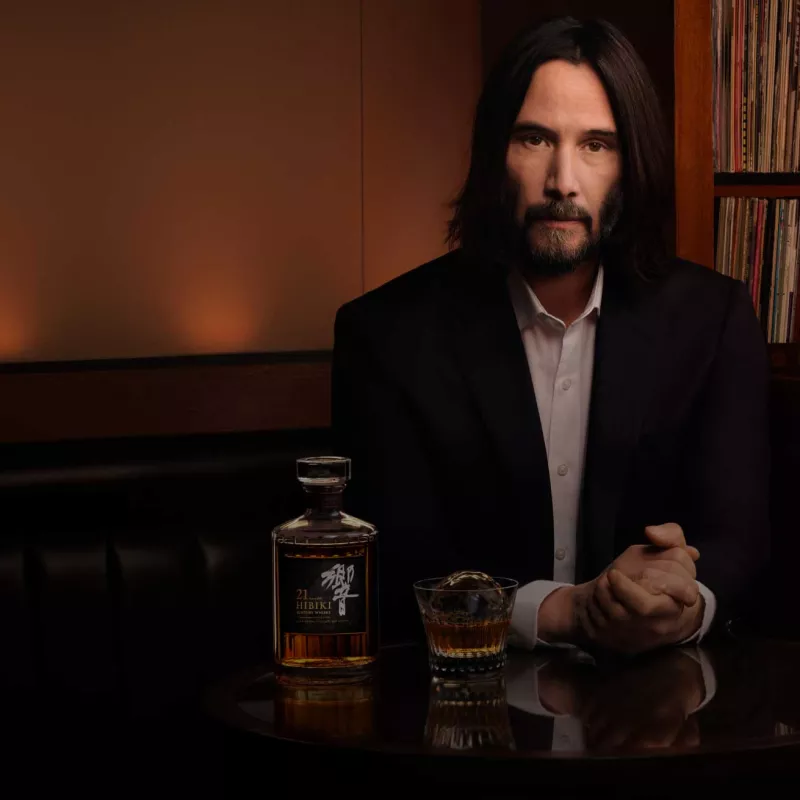 image of Keanu Reves with HOS 100- year anniversary bottle