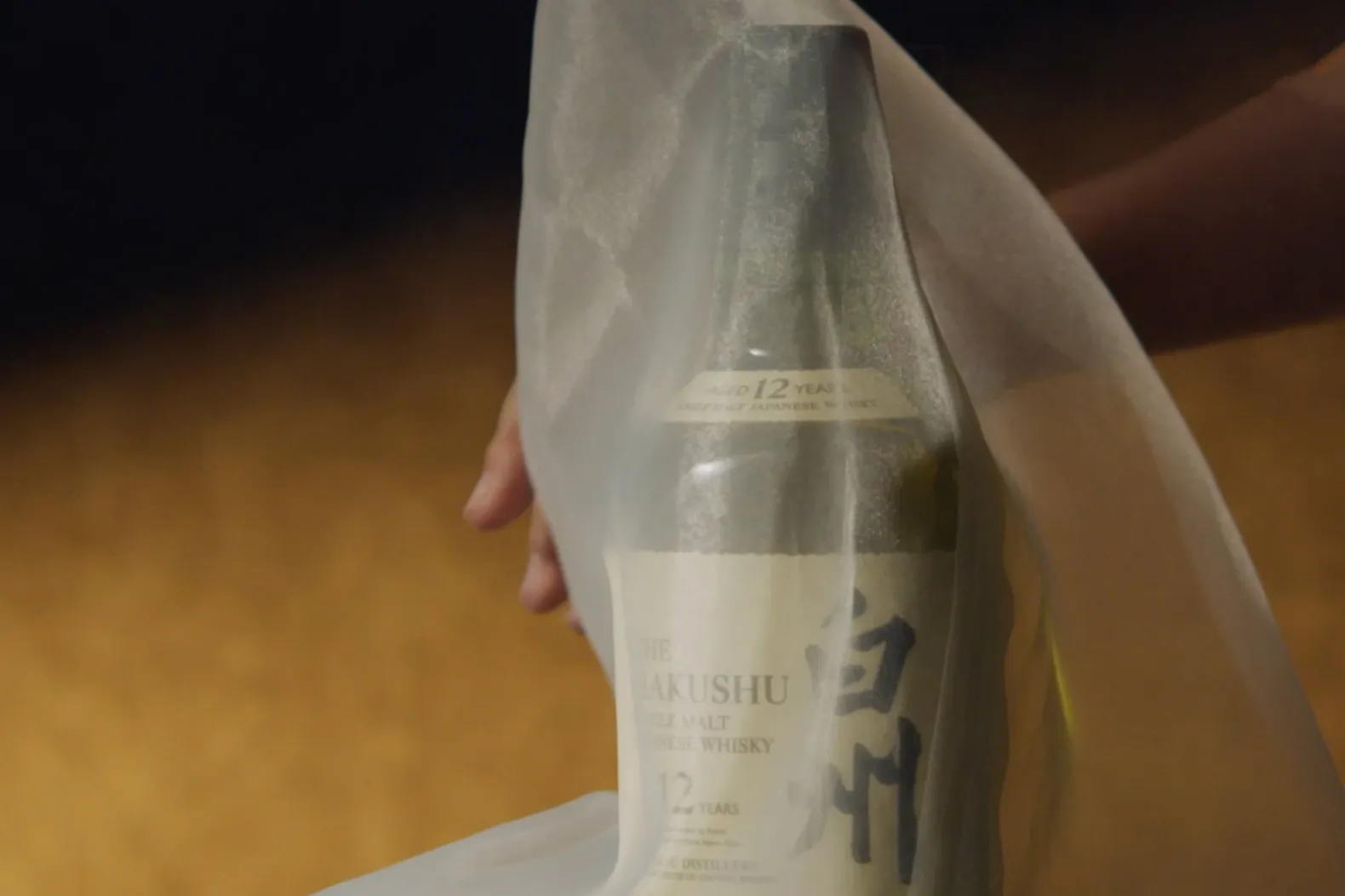 Close-up of a foggy bottle of The Hakushu 12-year-old single malt Japanese whisky.