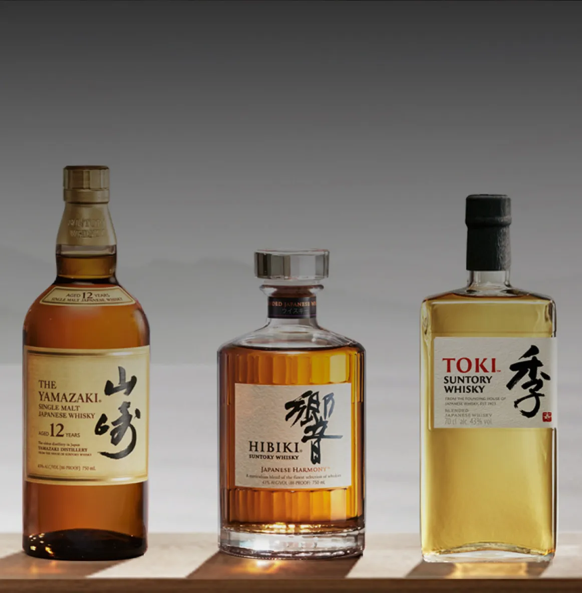 Three different bottles of suntory whisky.