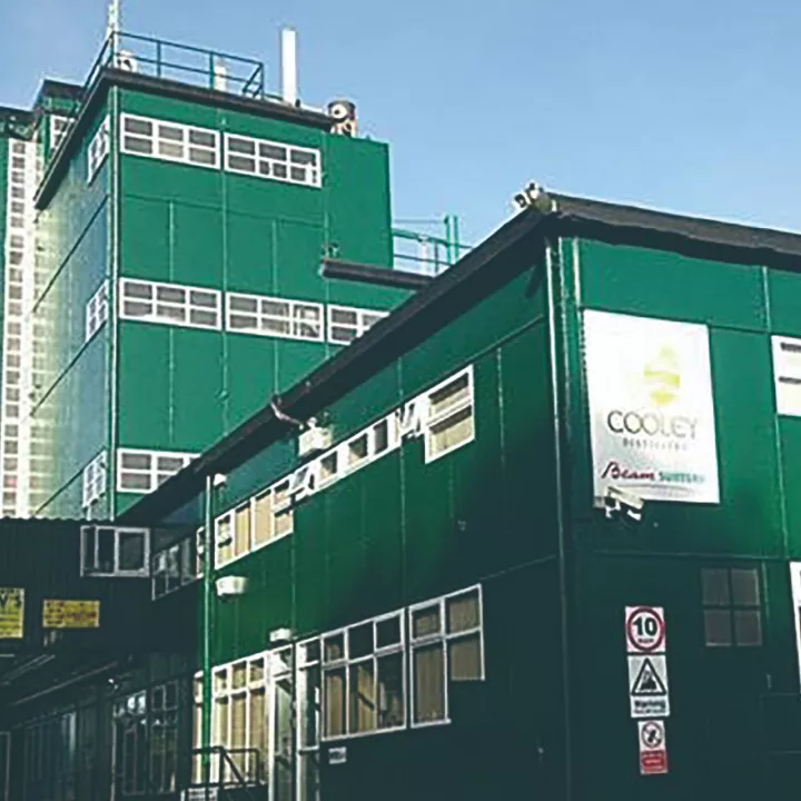 Green tiled Distillery building against blue sky in Ireland
