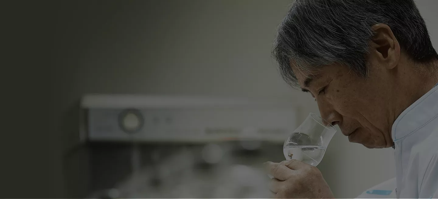 Japanese man is nosing a bell shaped glass filled with Haku Craft Vodka