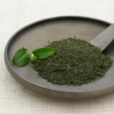 Ground up dried green tea leaves on a stone plate