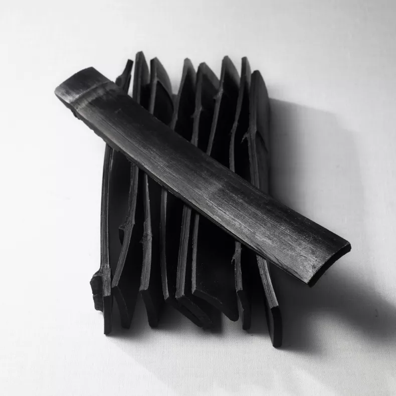 Long flat strips of black charcoal for filtering spirits
