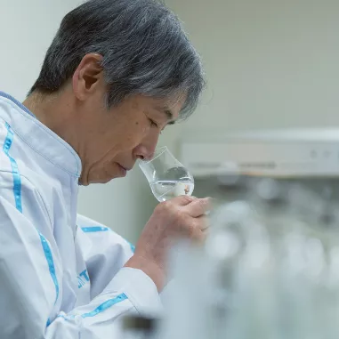 Man smelling the aroma of clear Japanese spirits in a glass
