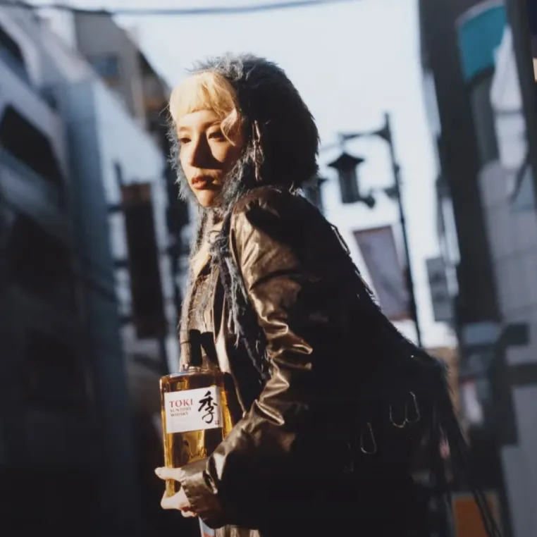 A girl holding a bottle of toki.