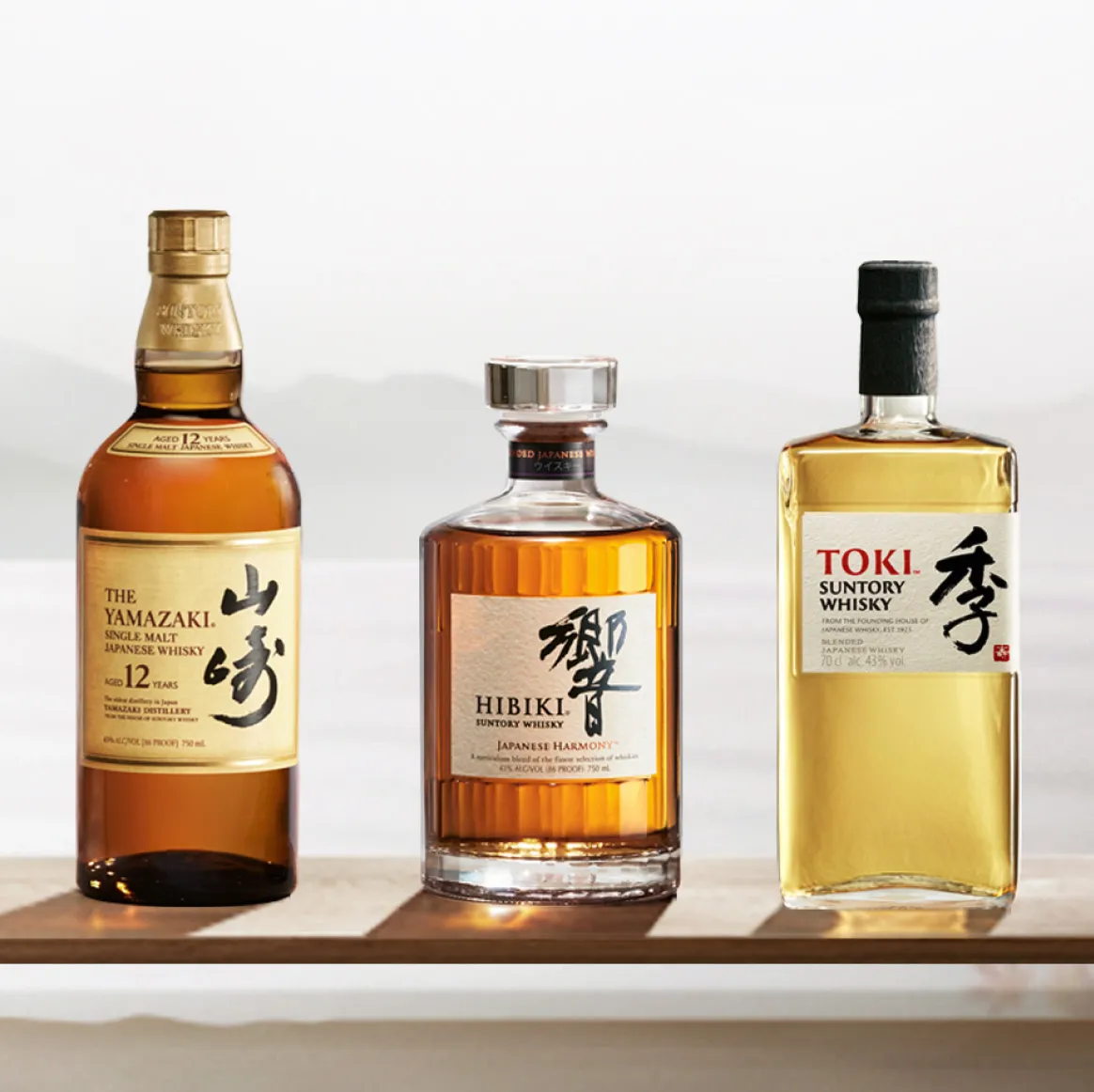 Three different bottles of suntory whisky.