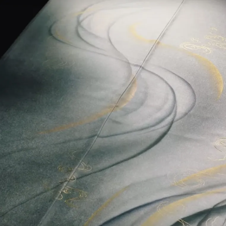 A close-up view of fabric featuring intricate gold writing, showcasing the texture and elegance of the material.