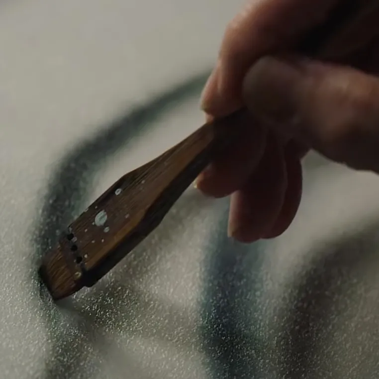 A person skillfully uses a brush to create a vibrant piece of art on a canvas, showcasing their artistic talent.