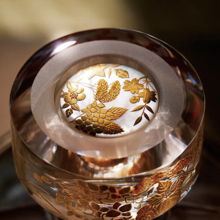 A decorative hibiki 40 bottle cap featuring intricate gold and white designs, showcasing elegance and artistry in its craftsmanship.