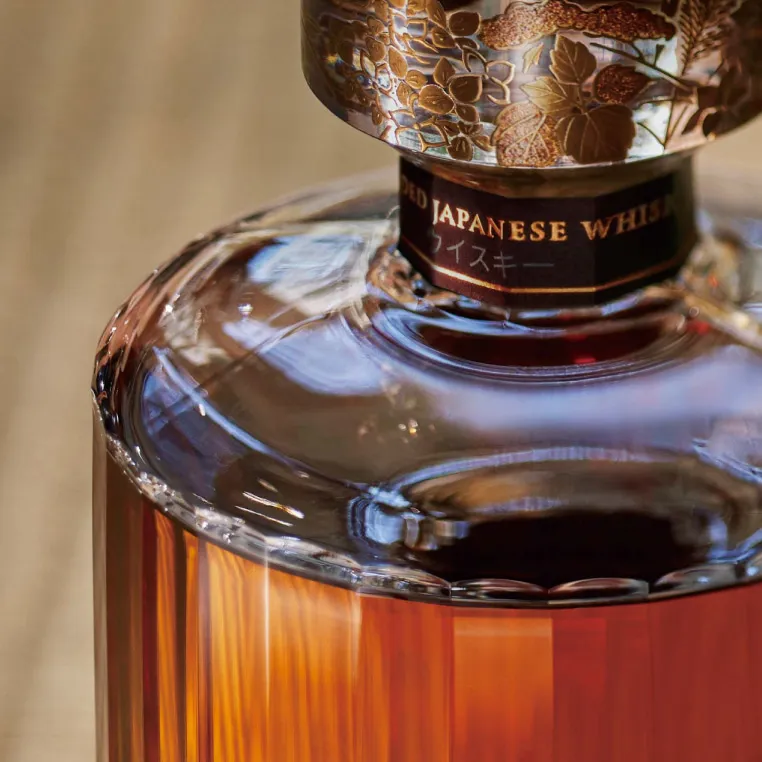 A bottle of Japanese whisky elegantly placed on a wooden table, showcasing its distinctive label and rich amber color.