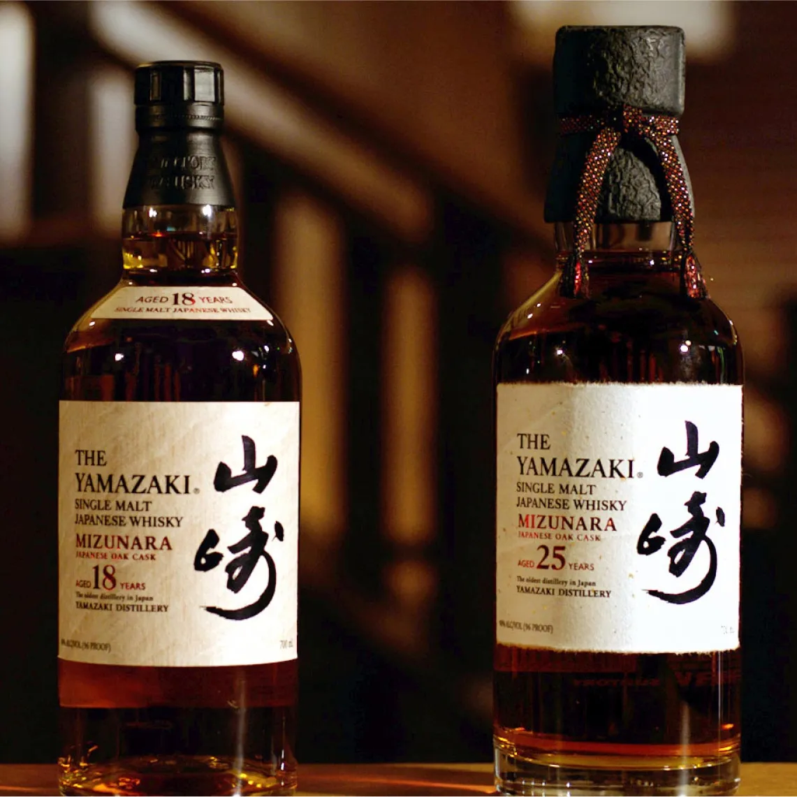 Two bottles of Yamazaki single malt Japanese whisky, one aged 18 years and the other 25 years, displayed elegantly.