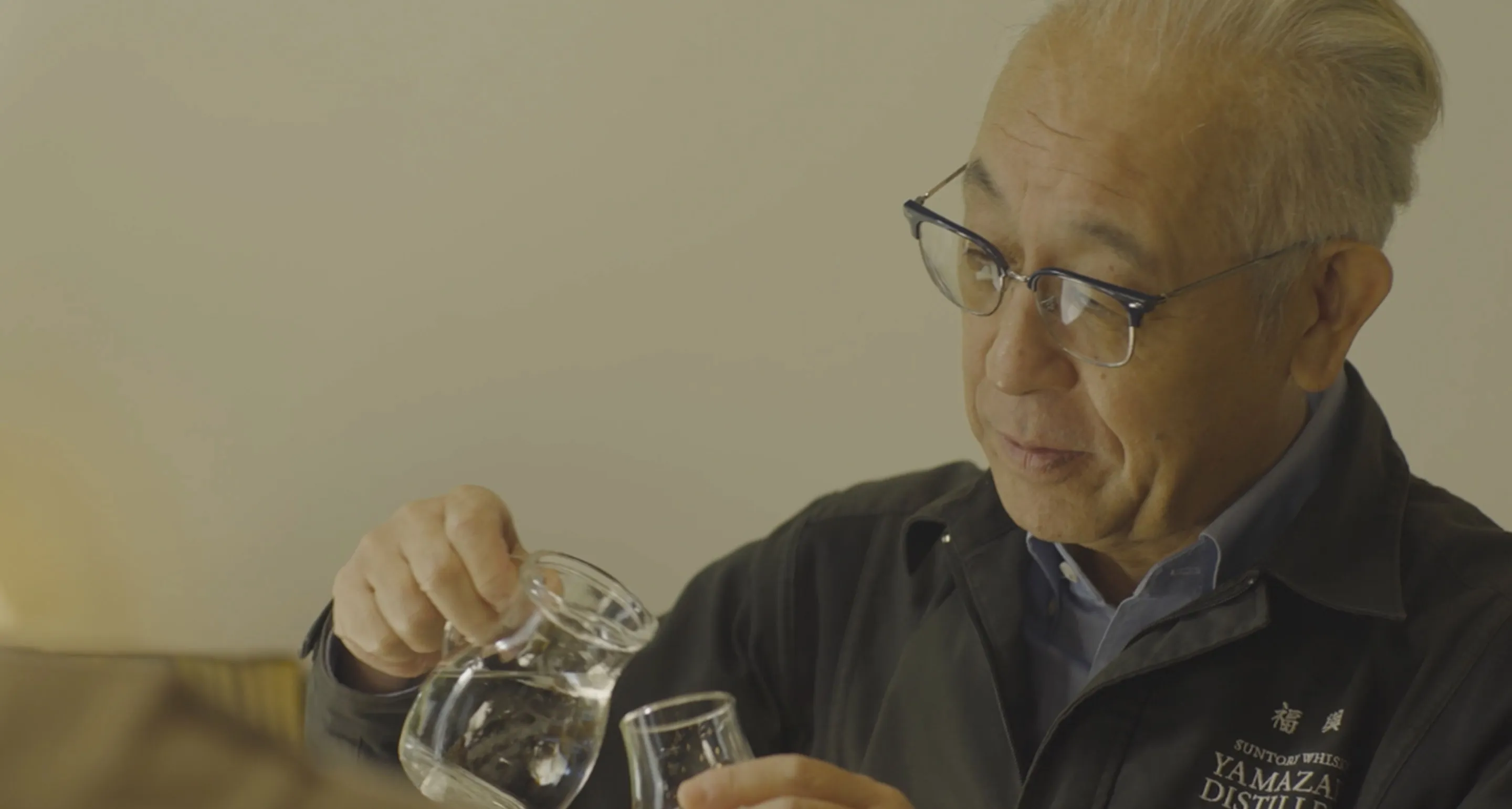 Mr. shinji poaring whisky into whisky glass