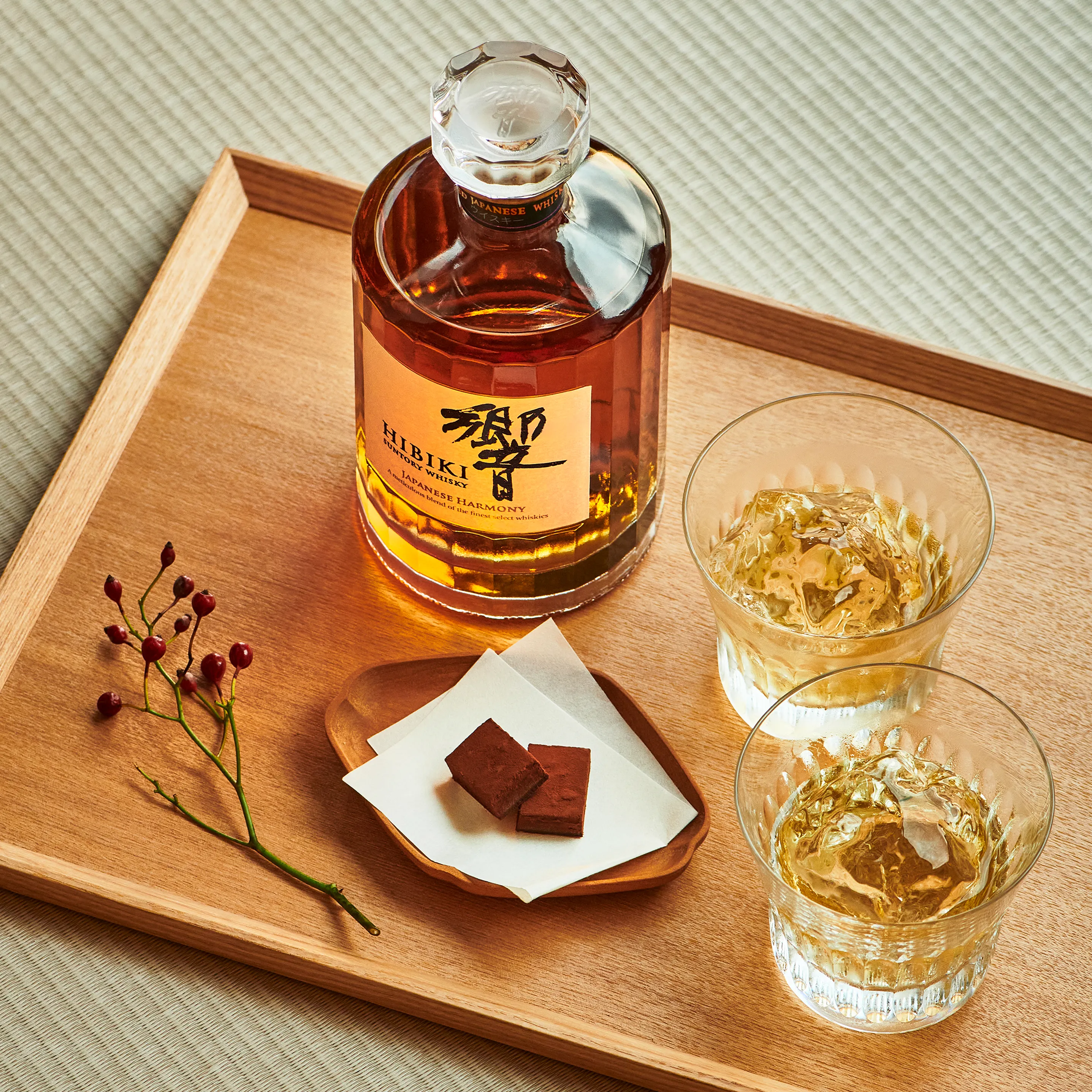 Suntory Whisky Hibiki served on wooden tray and next to whisky on the rocks cocktails
