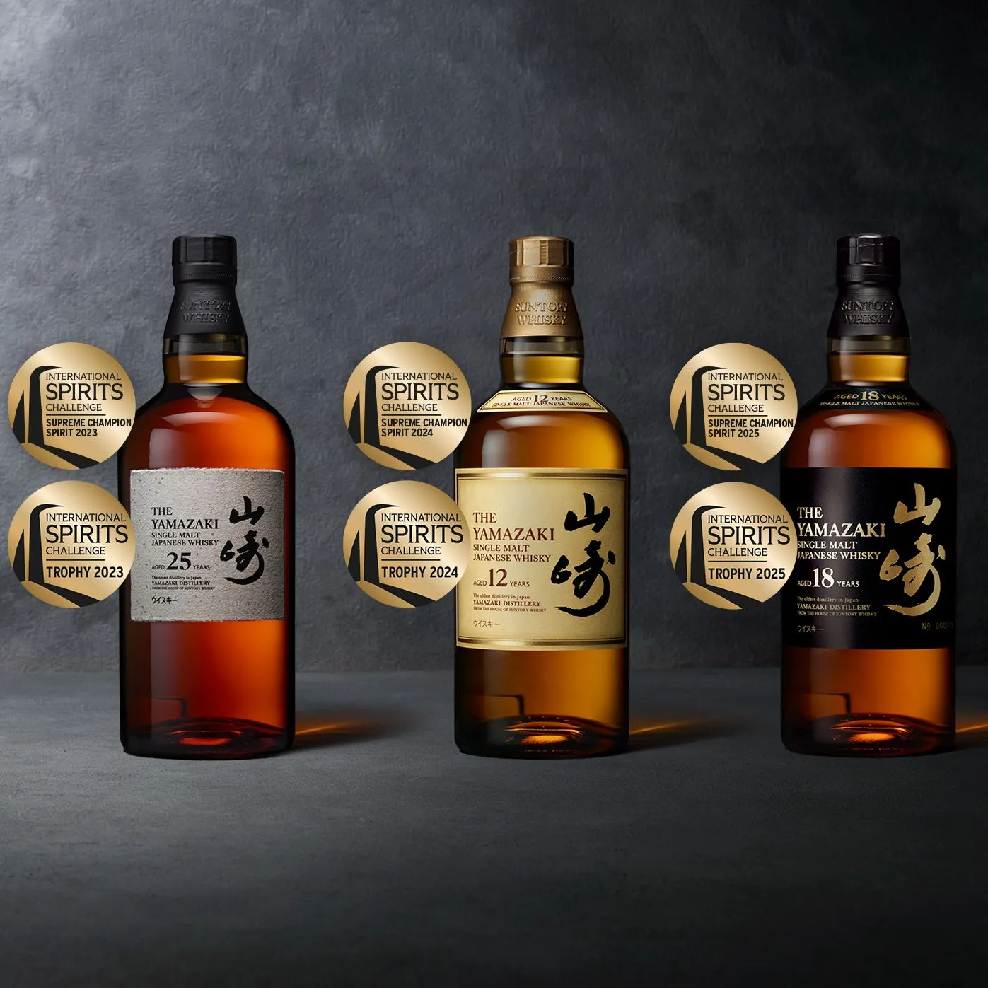 Three Yamazaki whiskies (25, 18, and 12 years) displayed with International Spirits Challenge awards on a dark background.