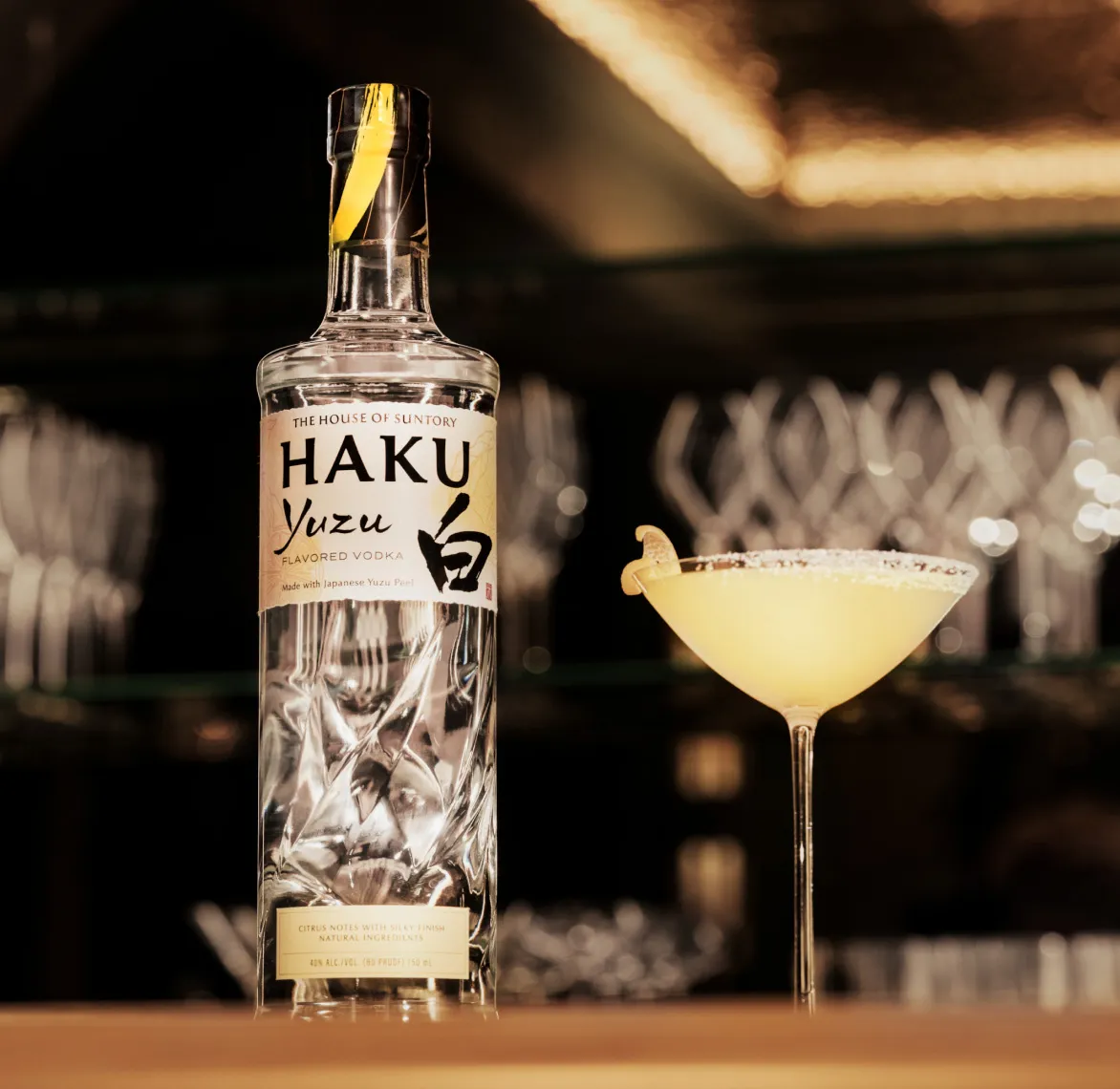 A bottle of Haku vodka displayed prominently on a polished bar surface.